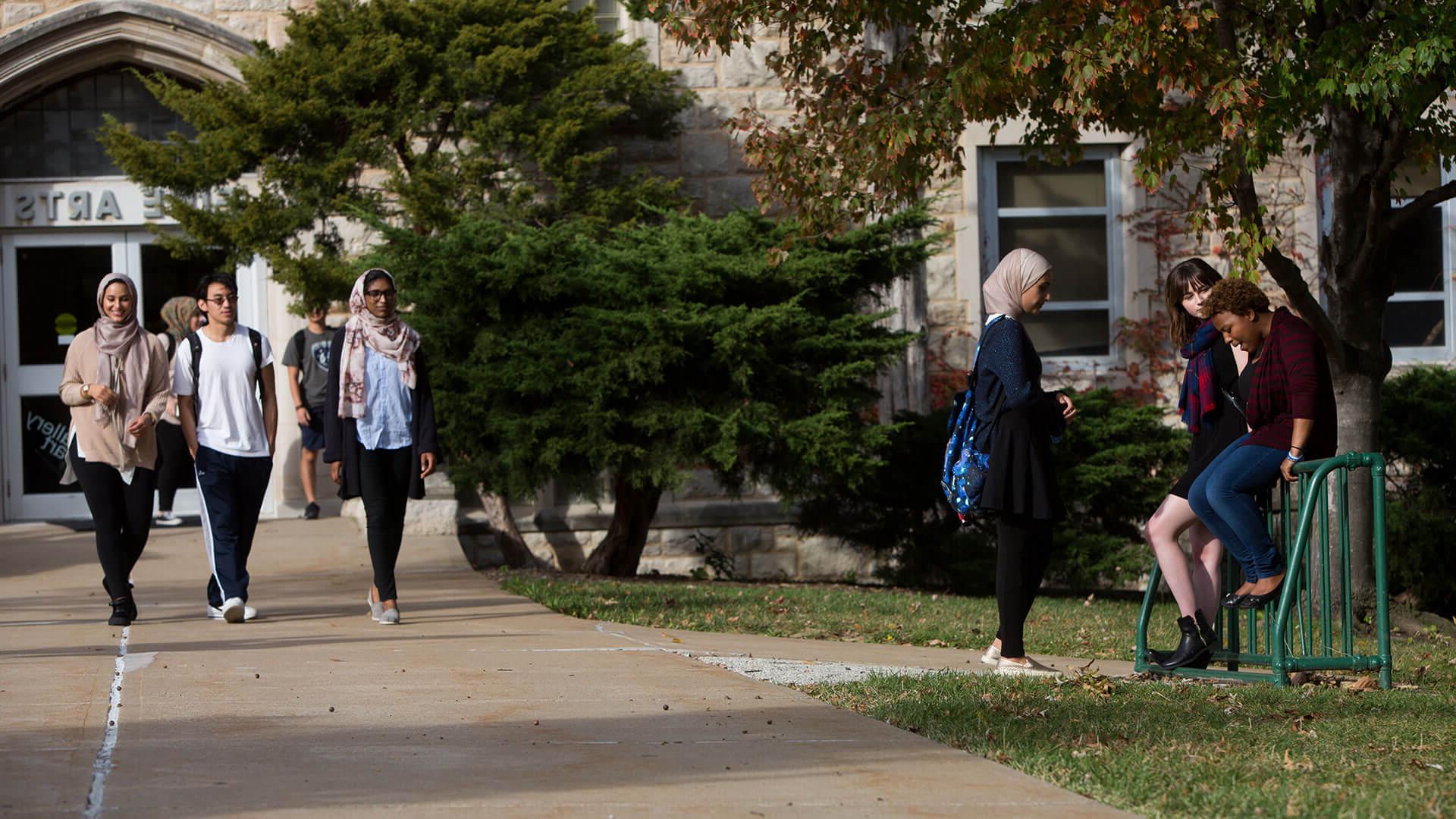 Three students laugh while standing in front of a fountain on the Country Club Plaza.